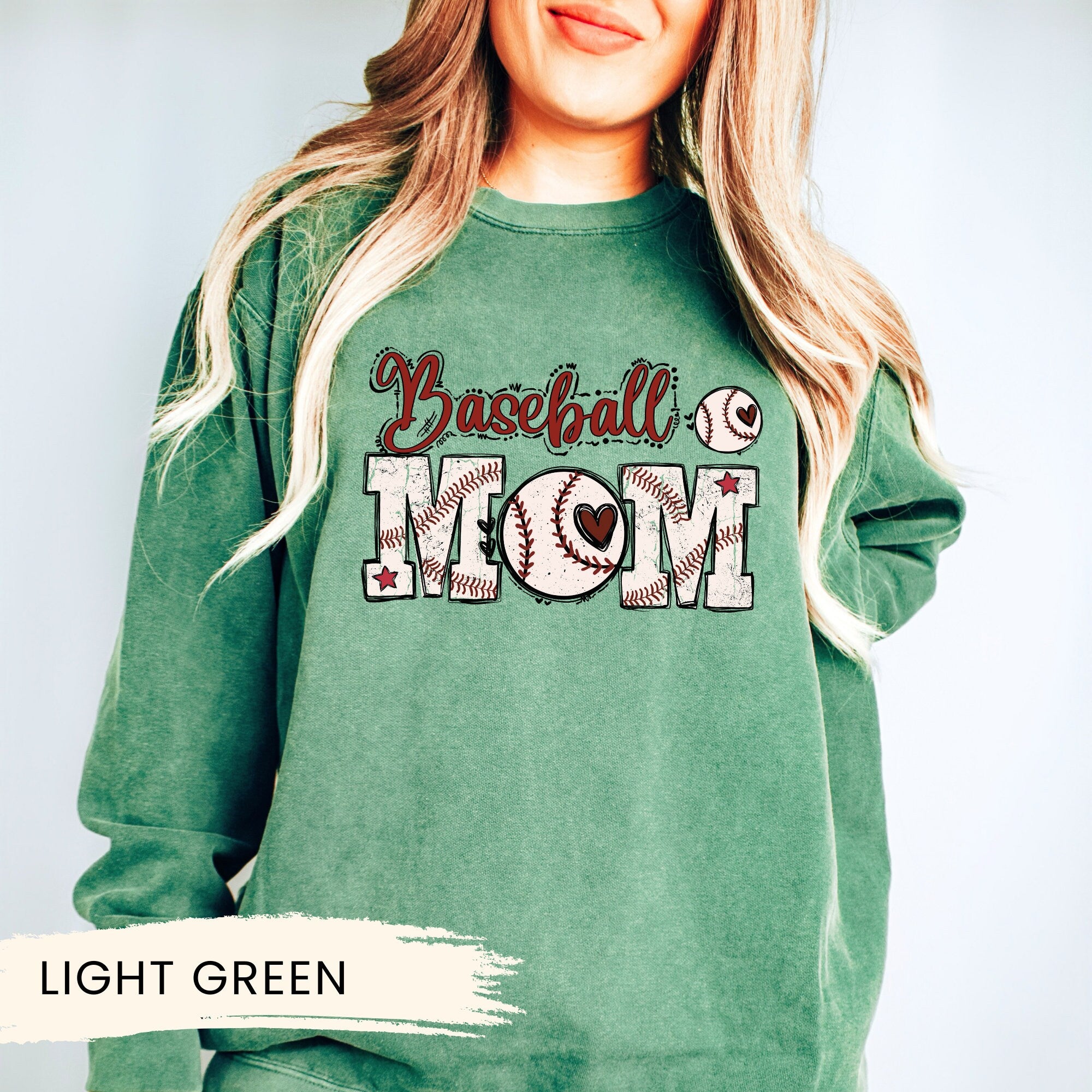 a woman wearing a green baseball mom sweatshirt