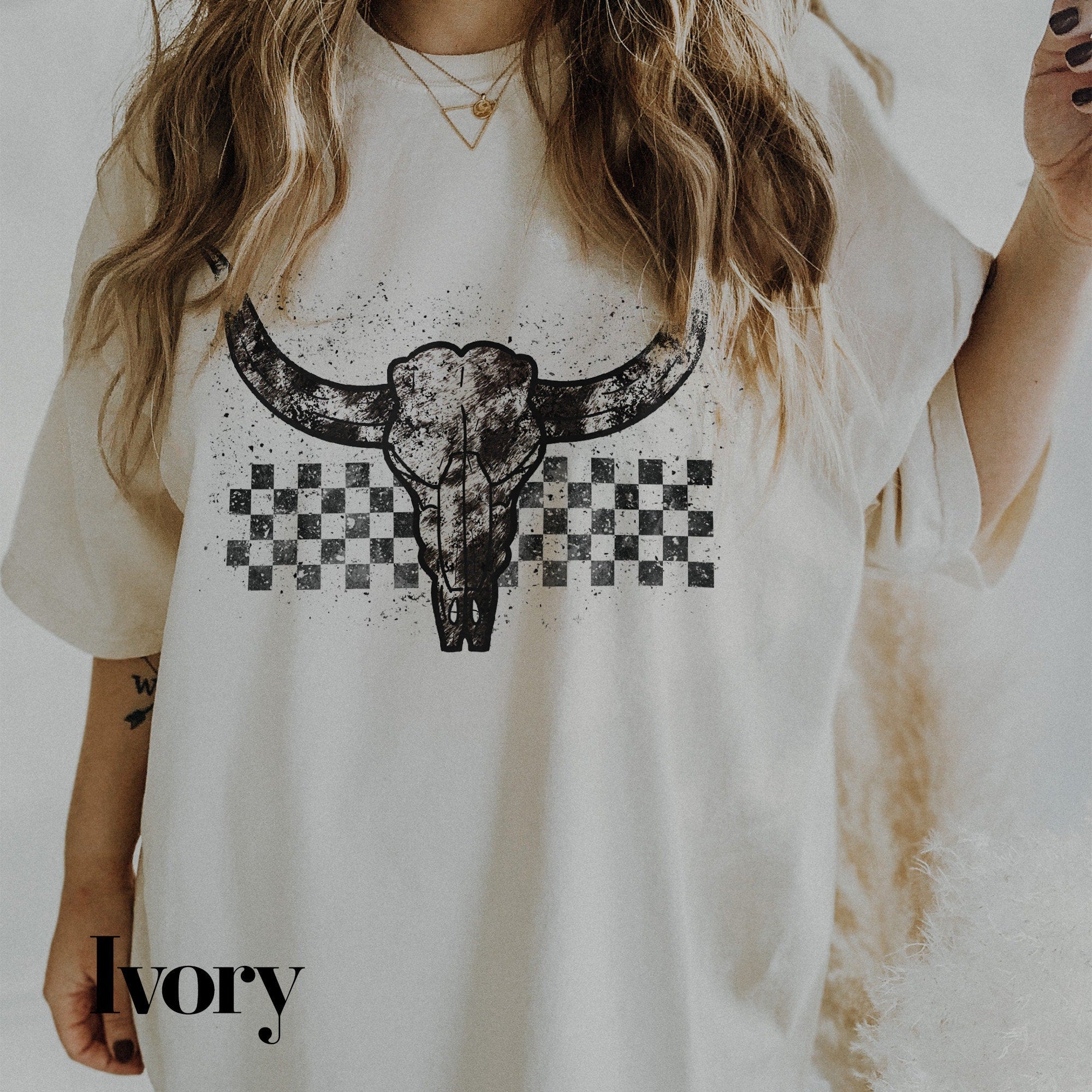a woman wearing a white shirt with a cow skull on it