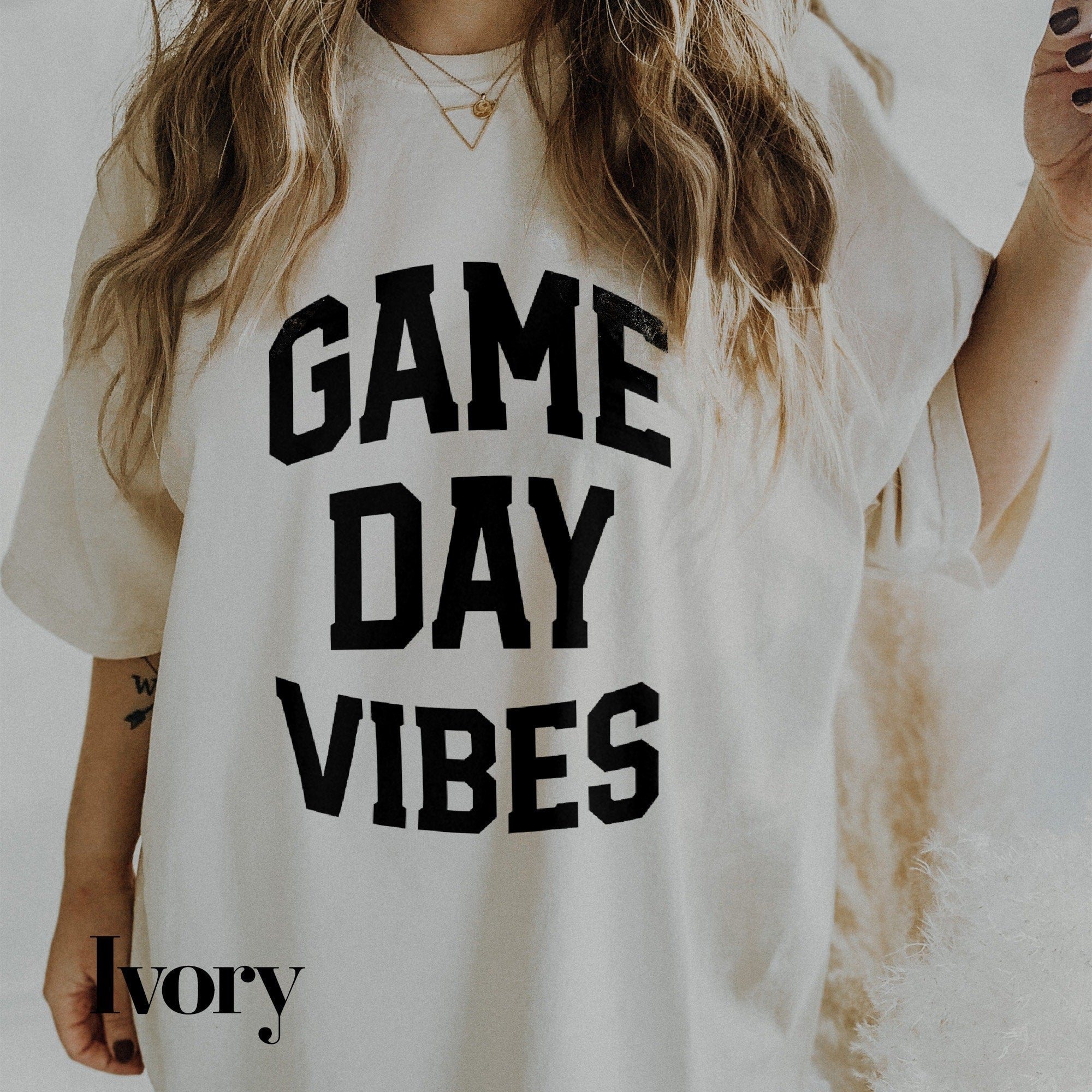 a woman with long hair wearing a game day shirt