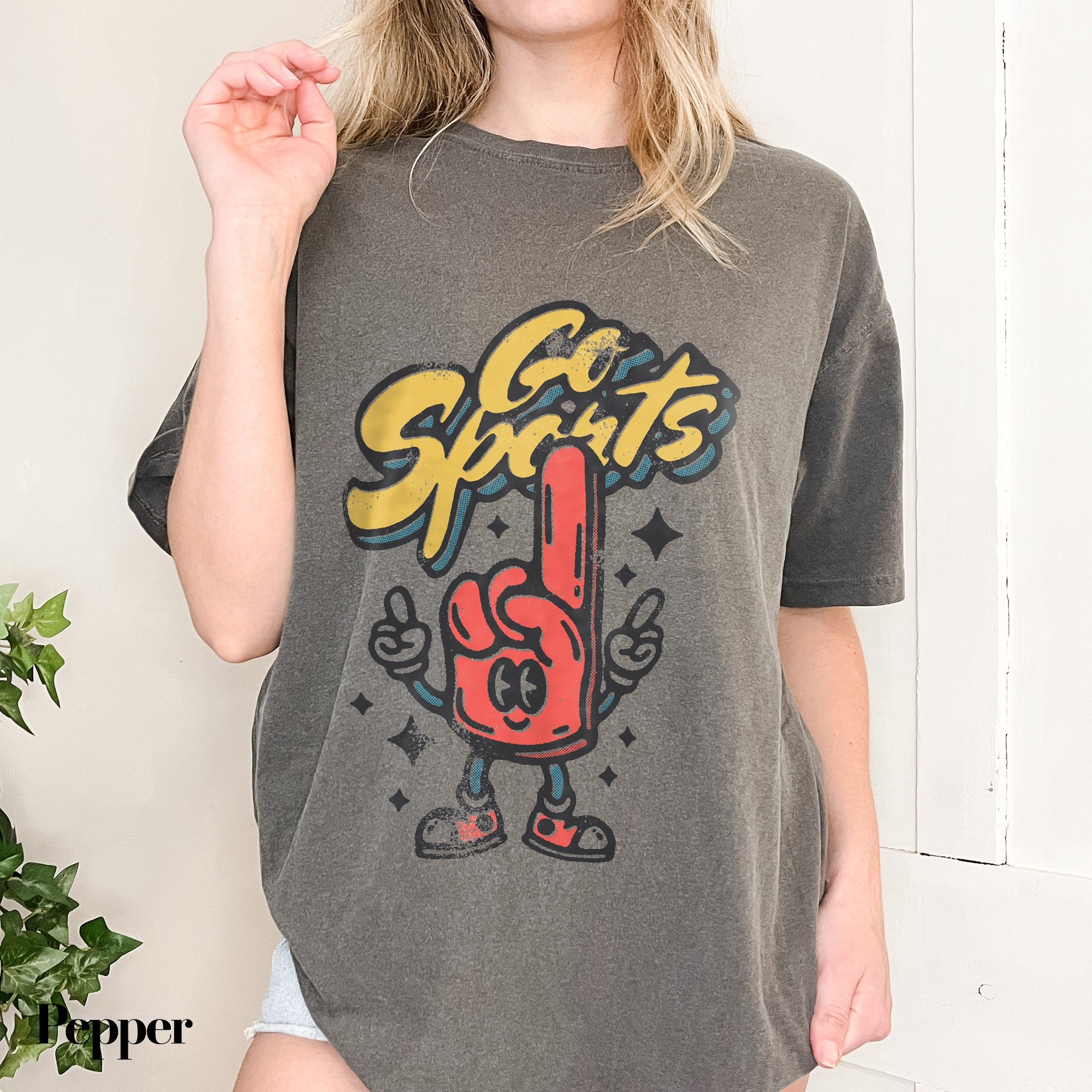 a woman wearing a gray shirt with a peace sign on it