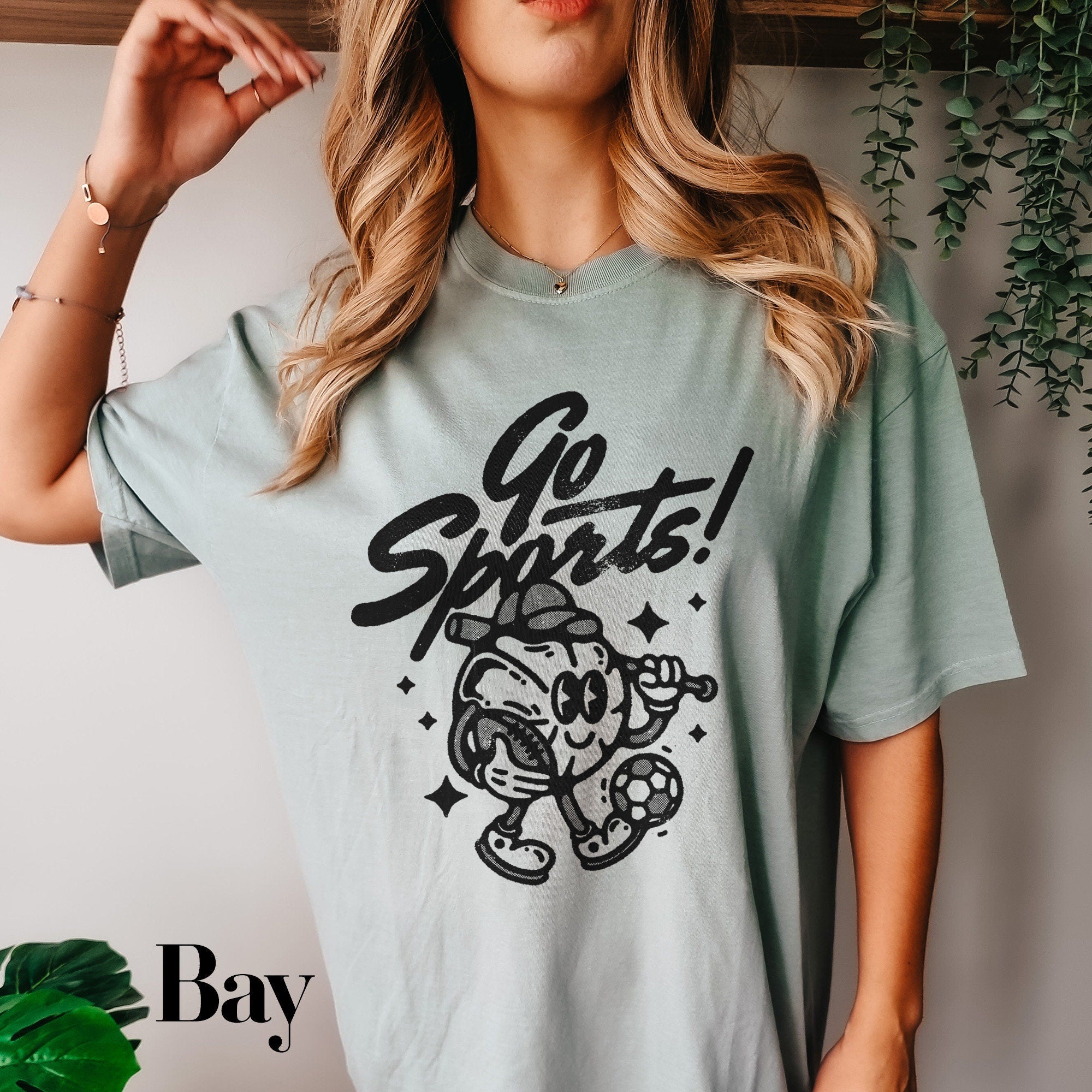 a woman wearing a gray shirt with a cartoon character on it