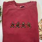 a red t - shirt with three gingerbreads on it