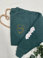 a green sweatshirt with a heart and name on it