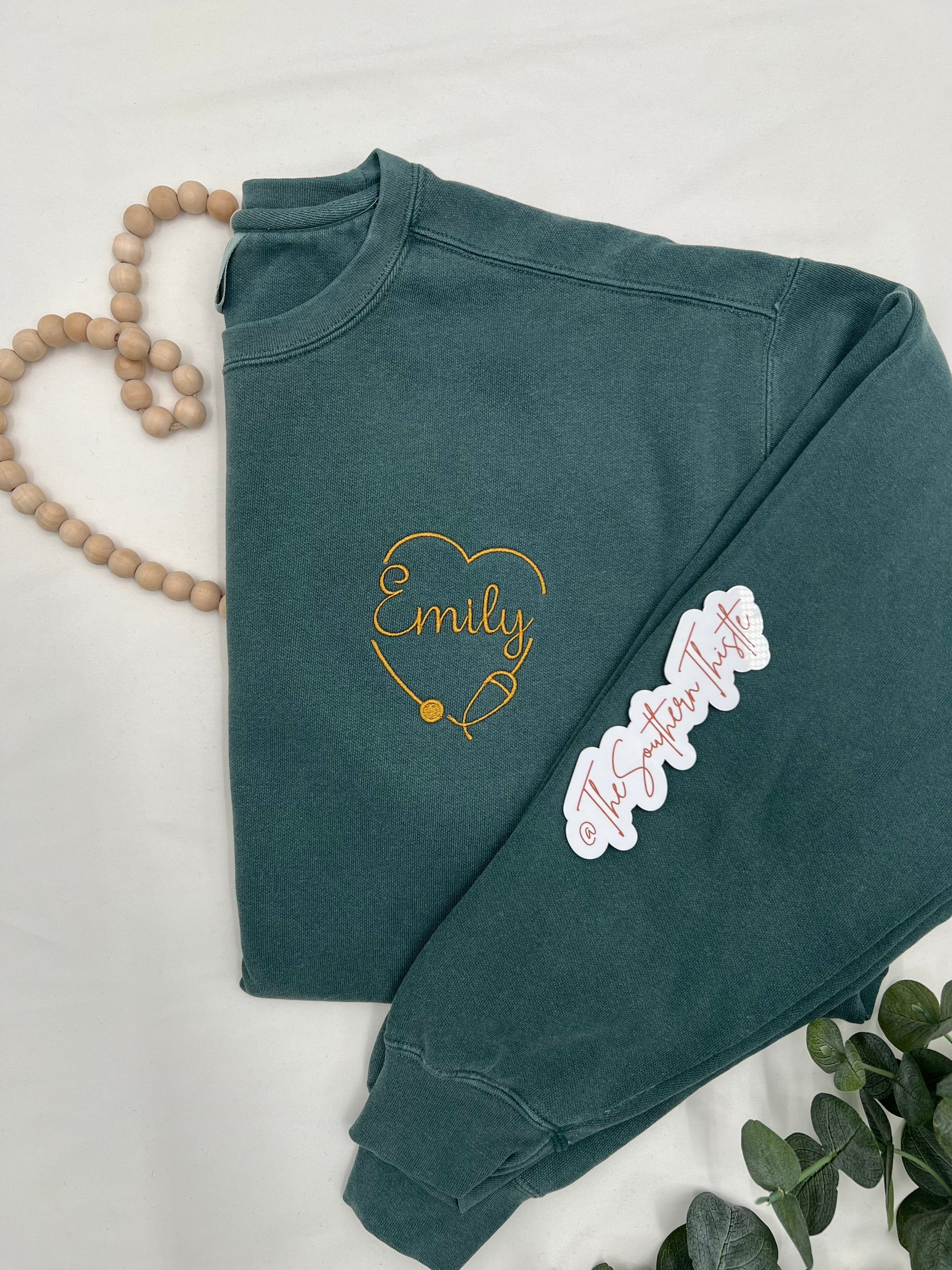 a green sweatshirt with a heart and name on it