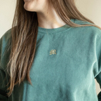 a woman with long hair wearing a green sweatshirt