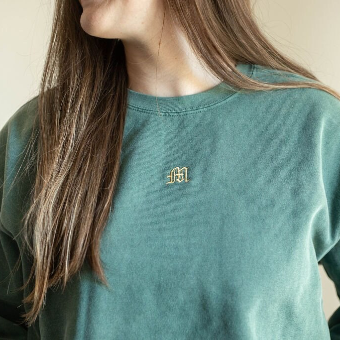 a woman with long hair wearing a green sweatshirt
