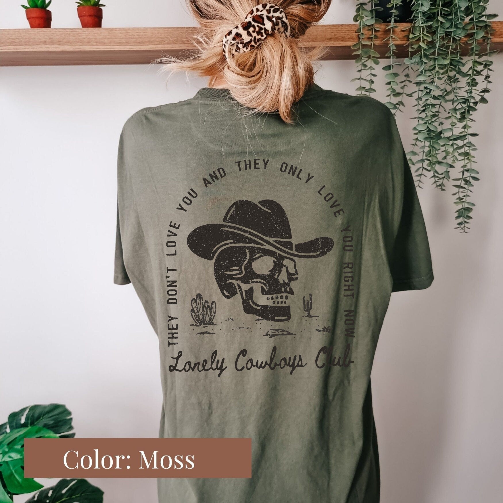 a woman wearing a green shirt with a skull on it