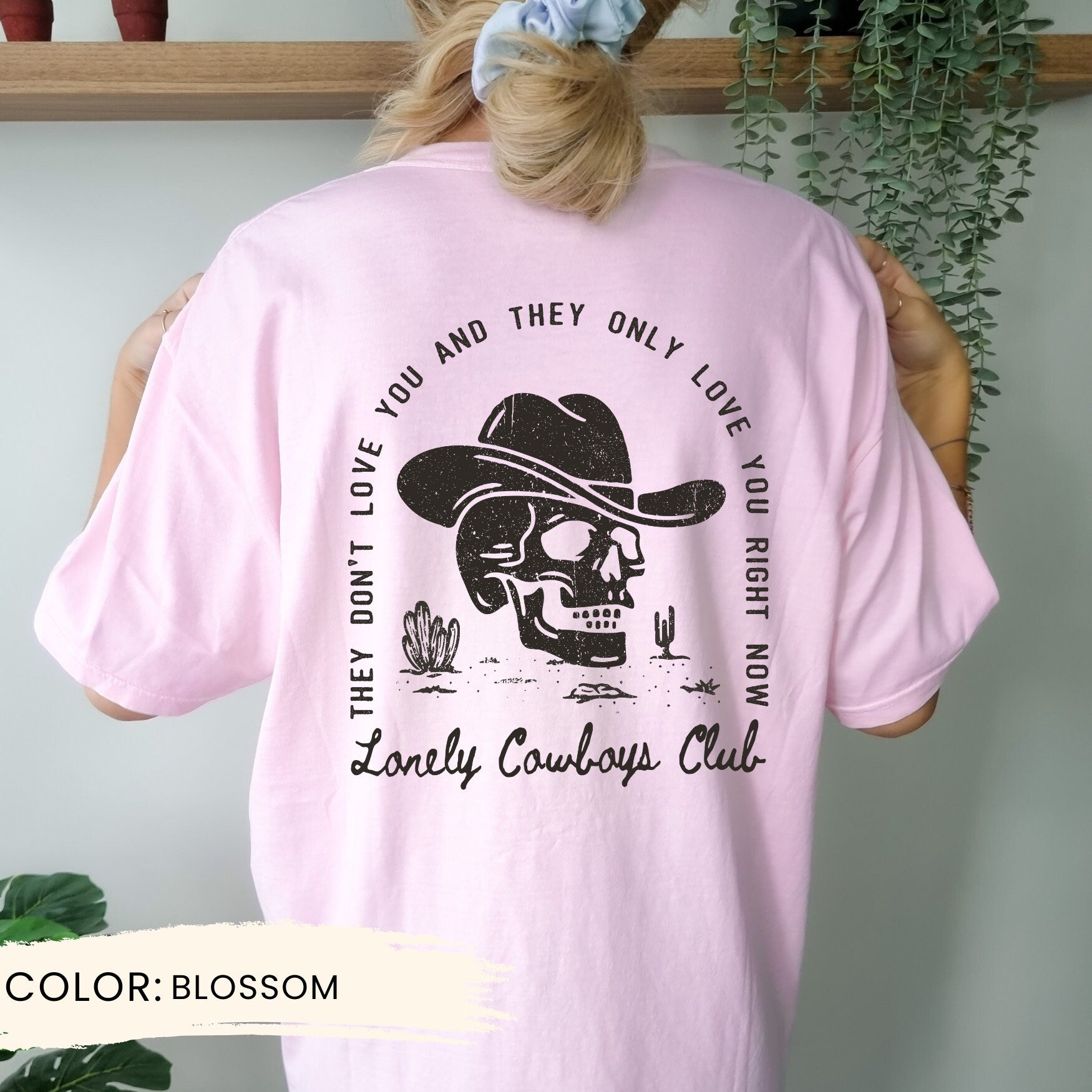 a woman wearing a pink shirt with a skull on it