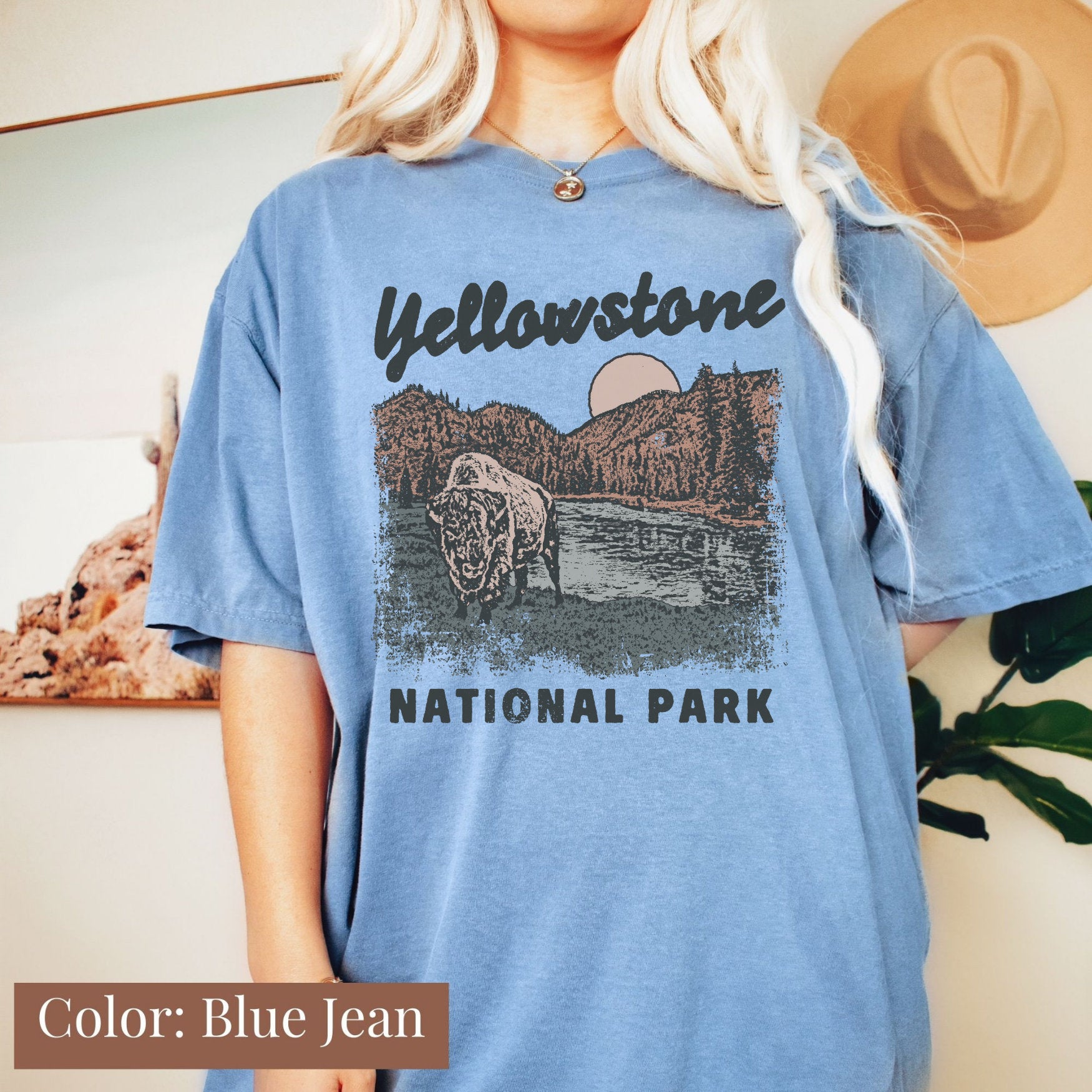 a blonde woman wearing a blue yellowstone national park t - shirt
