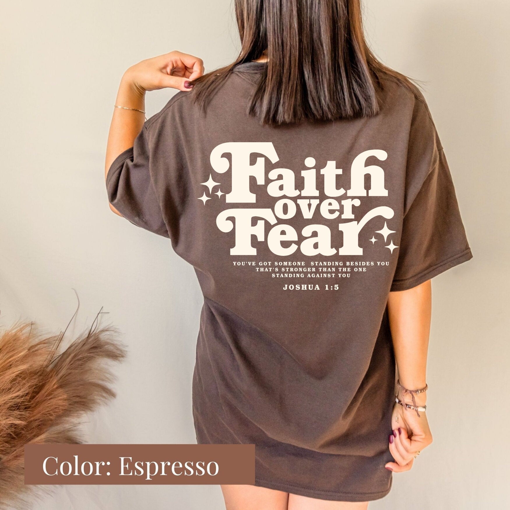 a woman wearing a brown faith over fear t - shirt
