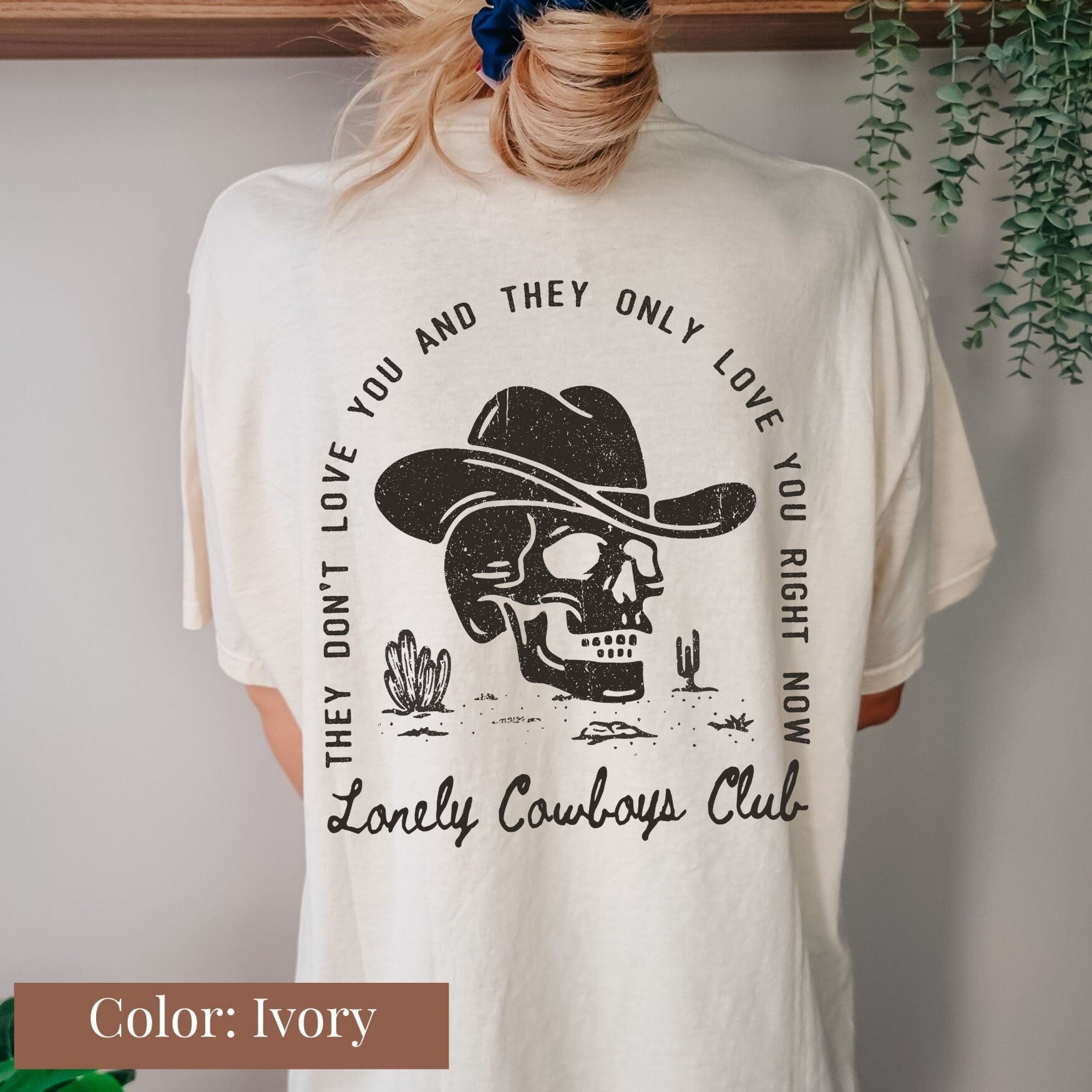 a woman wearing a white shirt with a skull wearing a cowboy hat