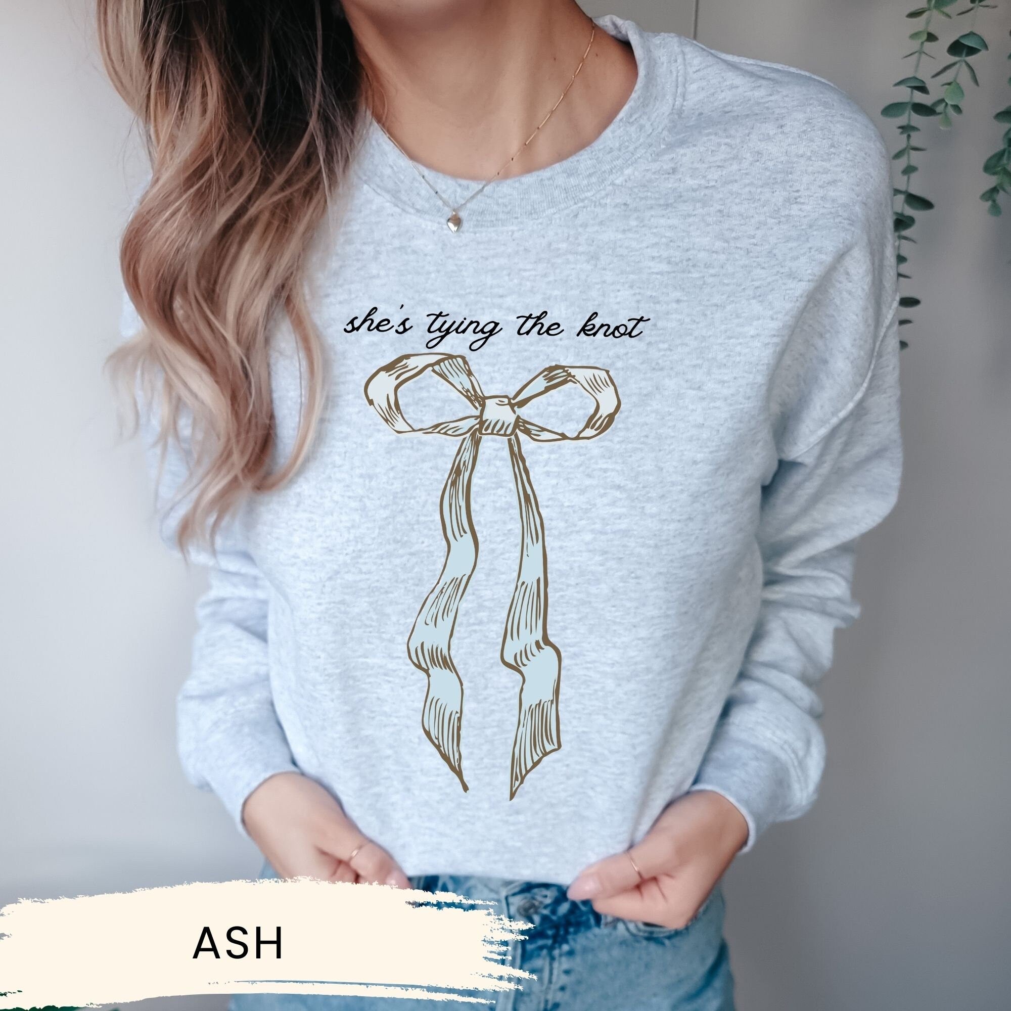 a woman wearing a sweater that says she&#39;s tying the knot