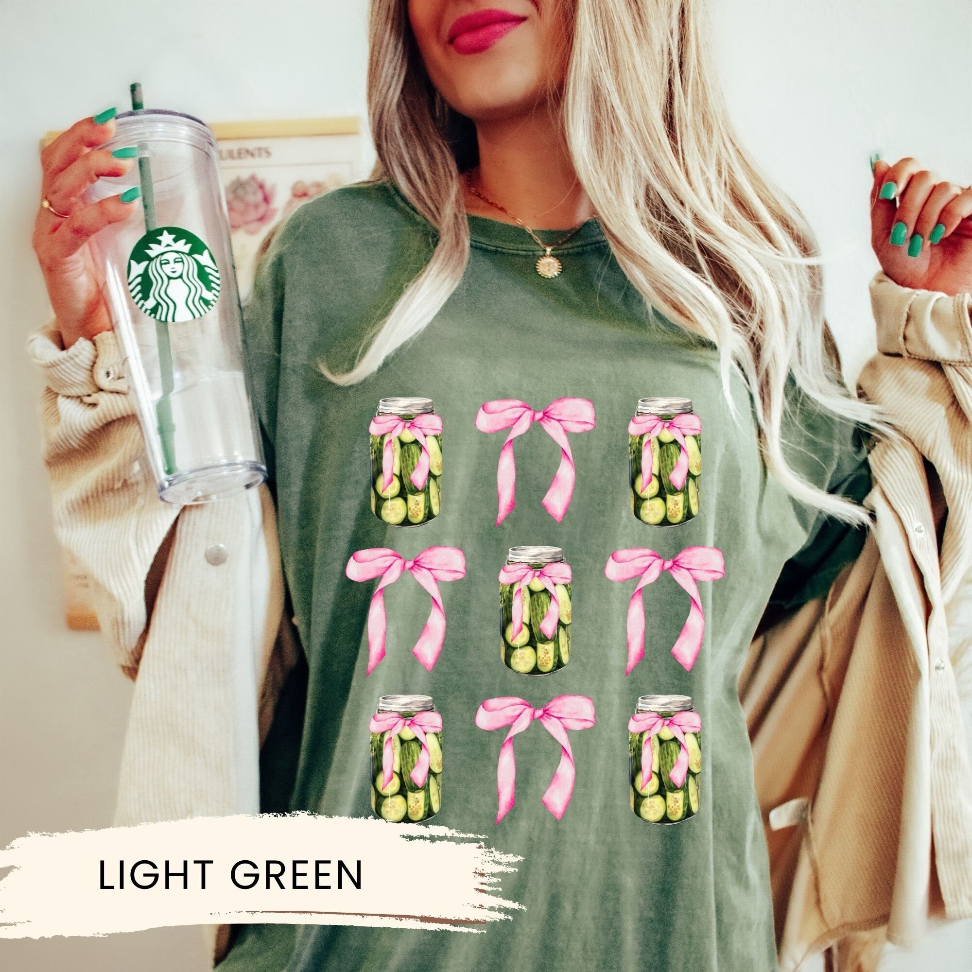a woman holding a starbucks cup and a green shirt