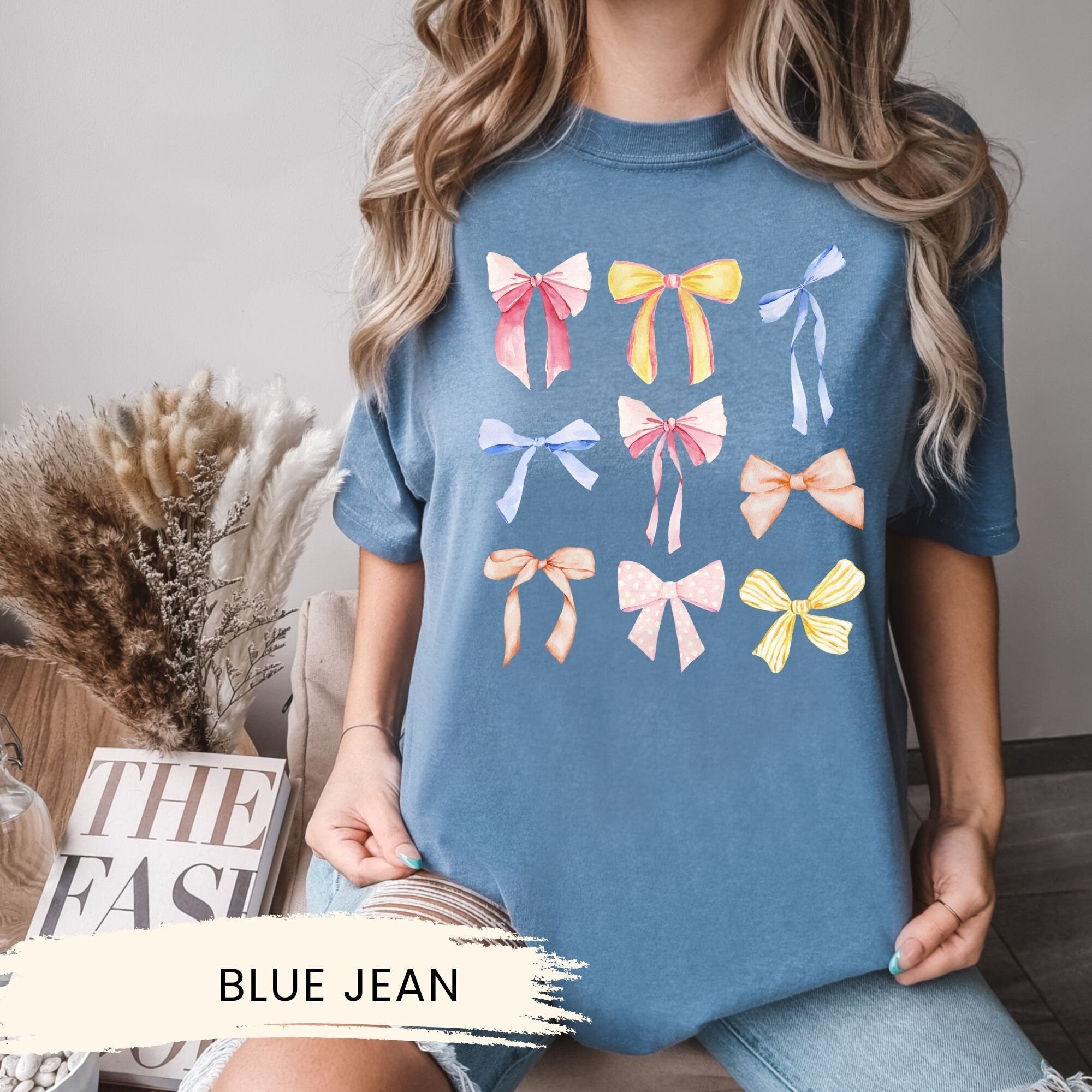 a woman wearing a blue jean shirt with bows on it