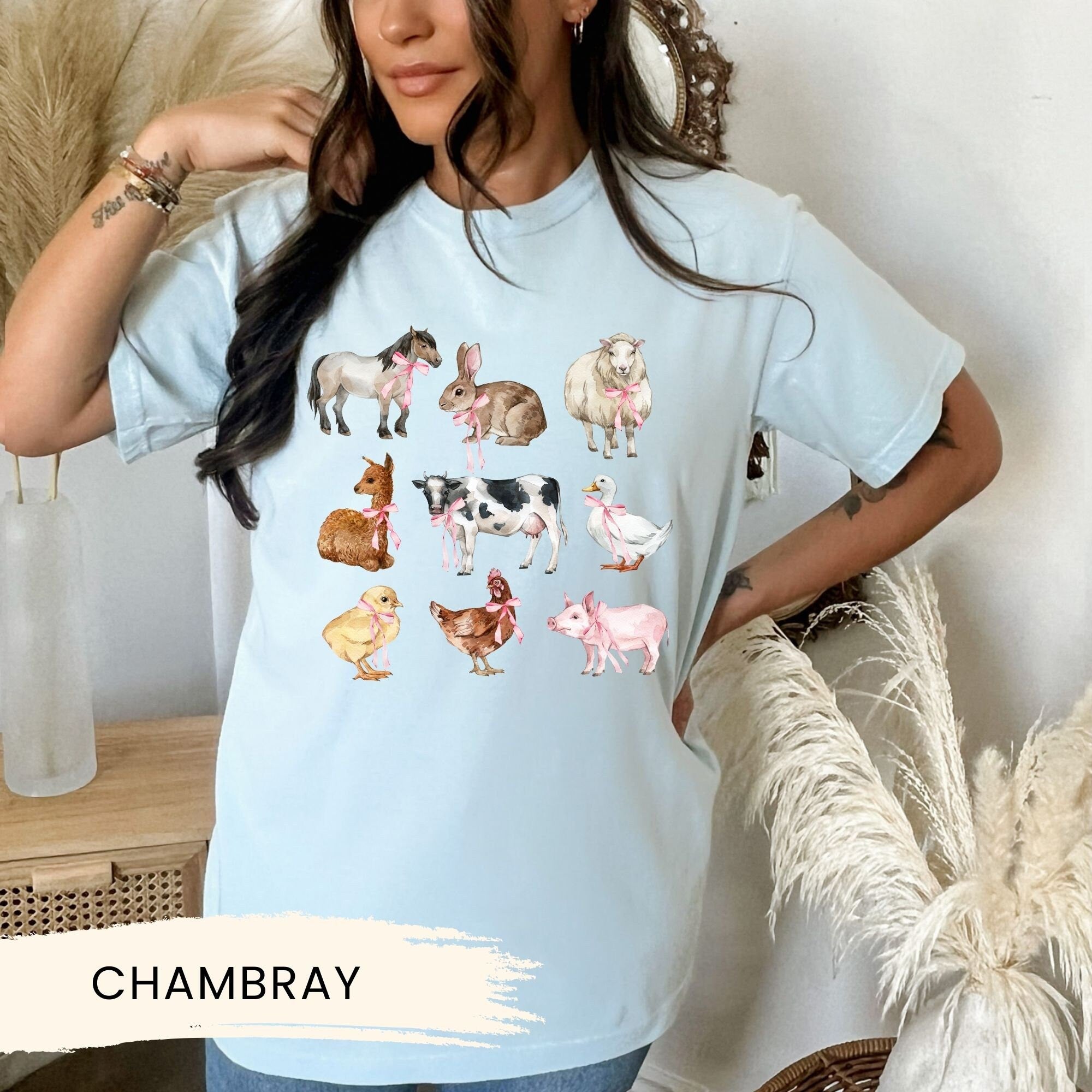 a woman wearing a blue t - shirt with farm animals on it