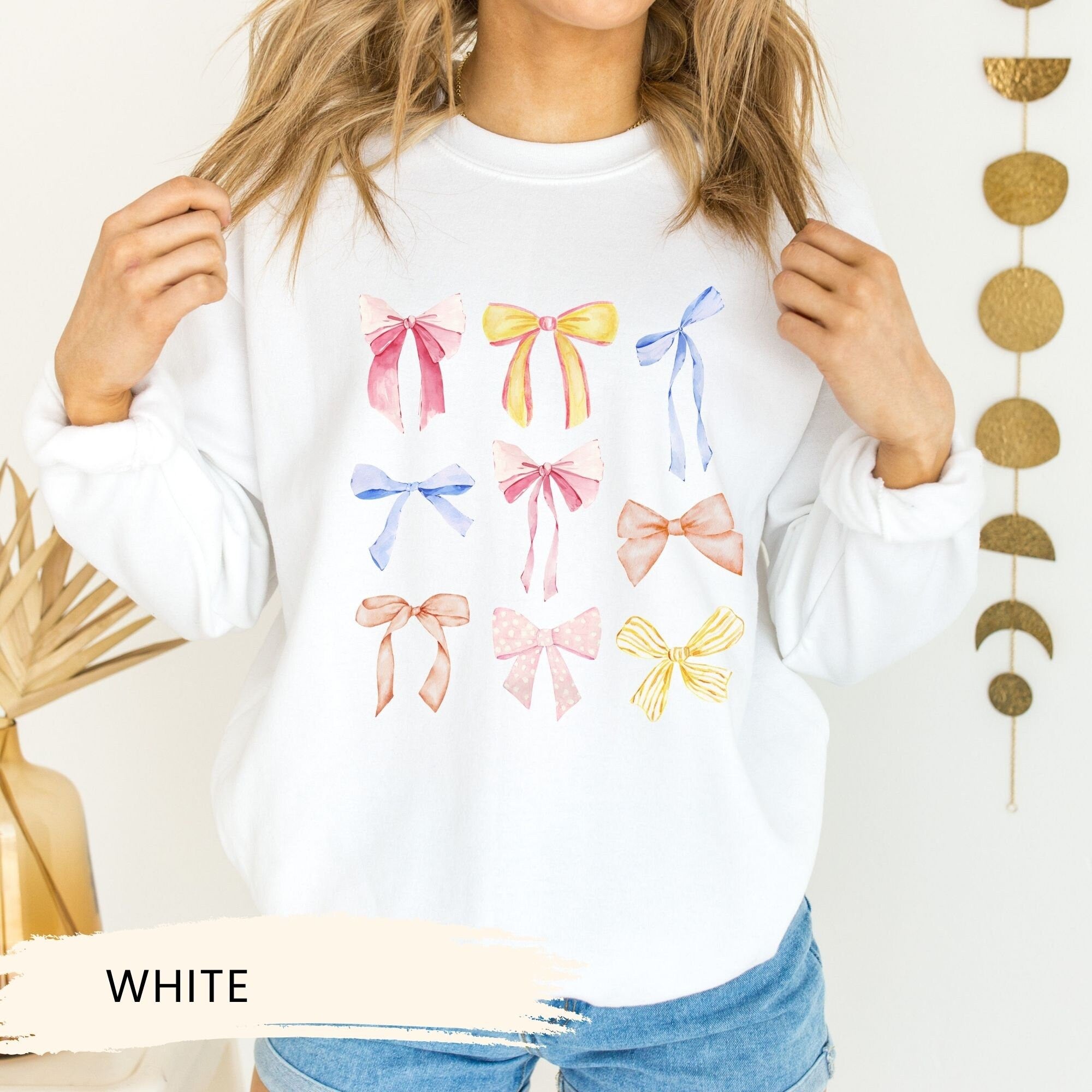a woman wearing a white shirt with bows on it