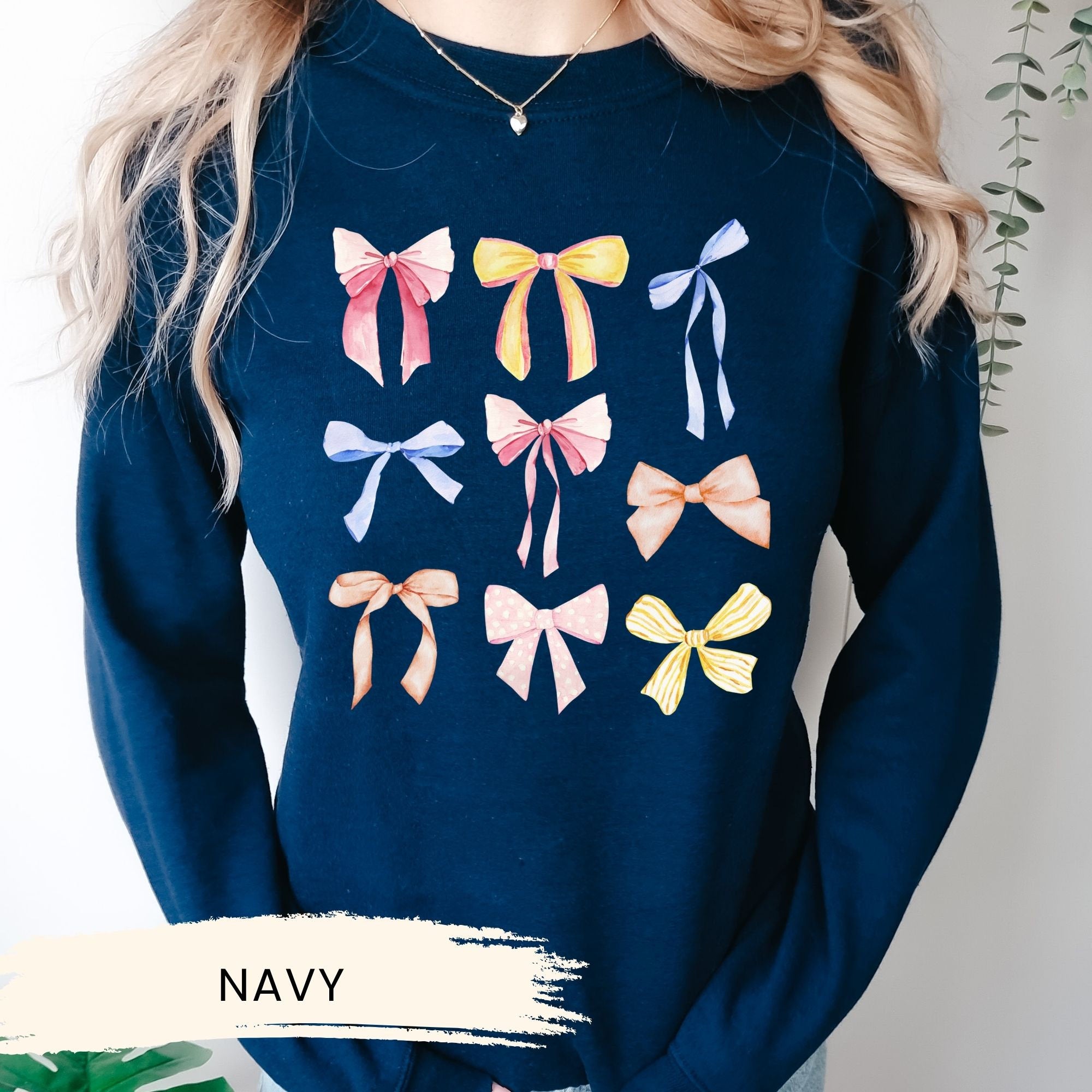 a woman wearing a navy sweater with bows on it