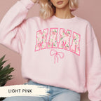 a woman wearing a pink sweatshirt with the word mama on it