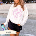 a woman standing on the beach holding a water bottle