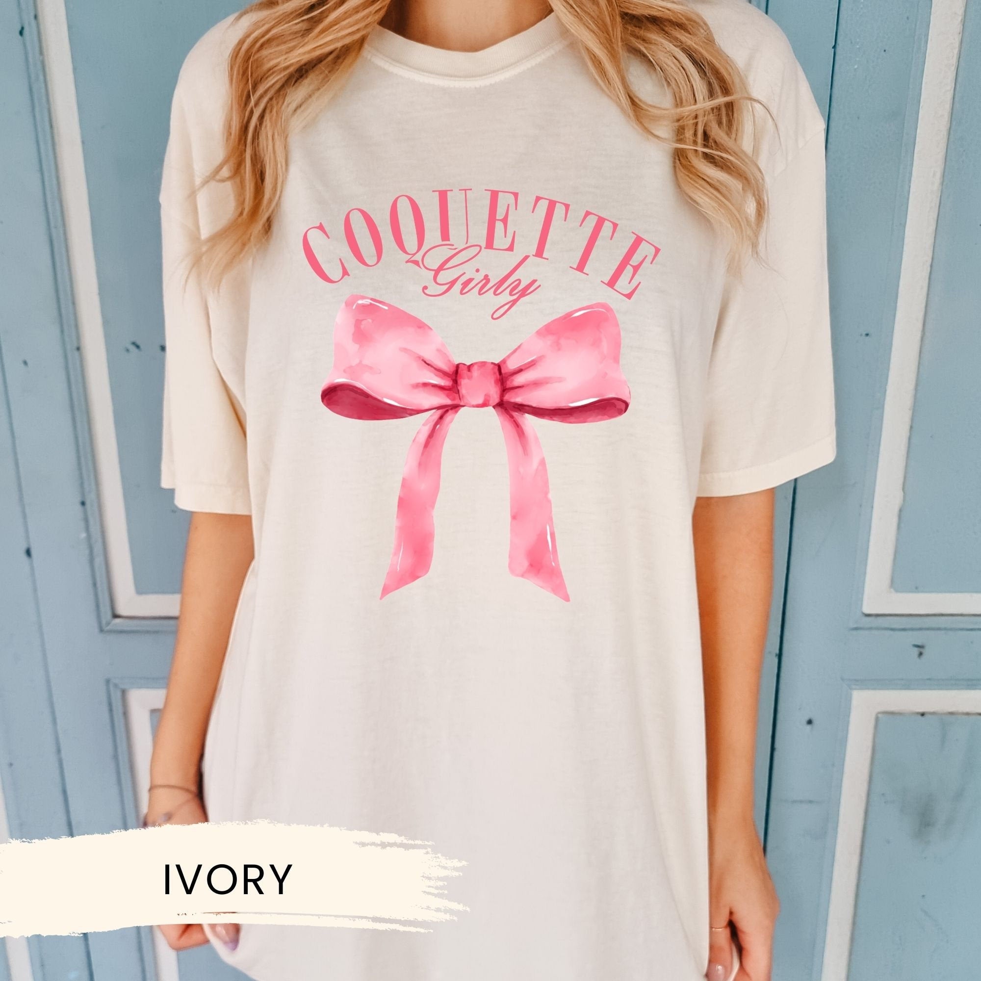 a woman wearing a white shirt with a pink bow on it