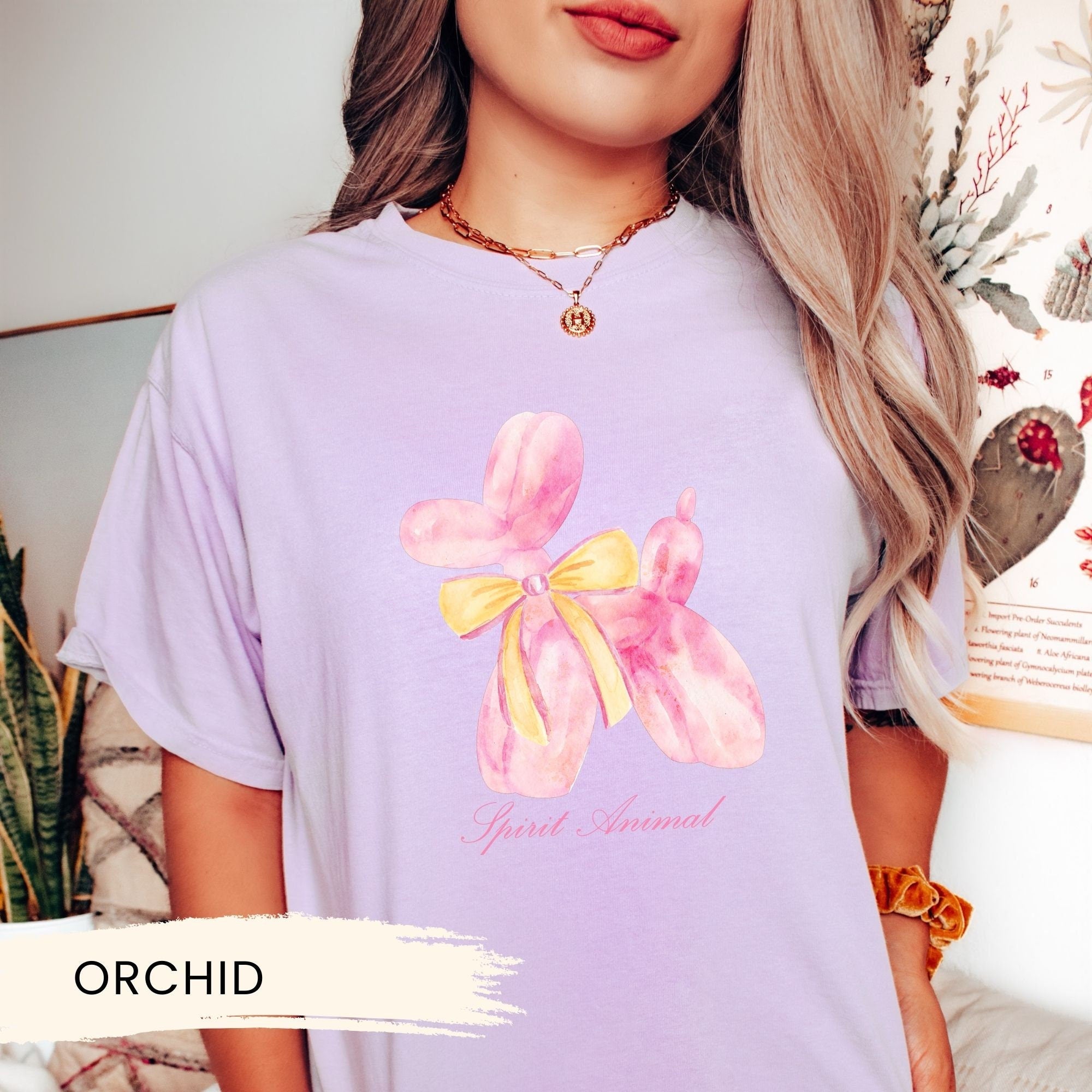 a woman wearing a purple shirt with a pink flower on it