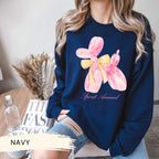 a woman wearing a navy sweatshirt with a pink flower on it