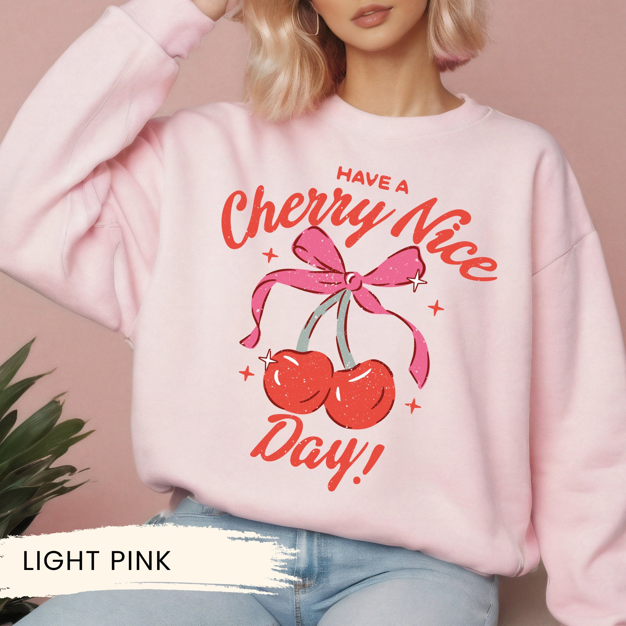 a woman wearing a pink sweatshirt that says have a cherry nice day