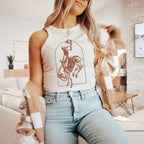 a woman sitting on a couch wearing a white tank top