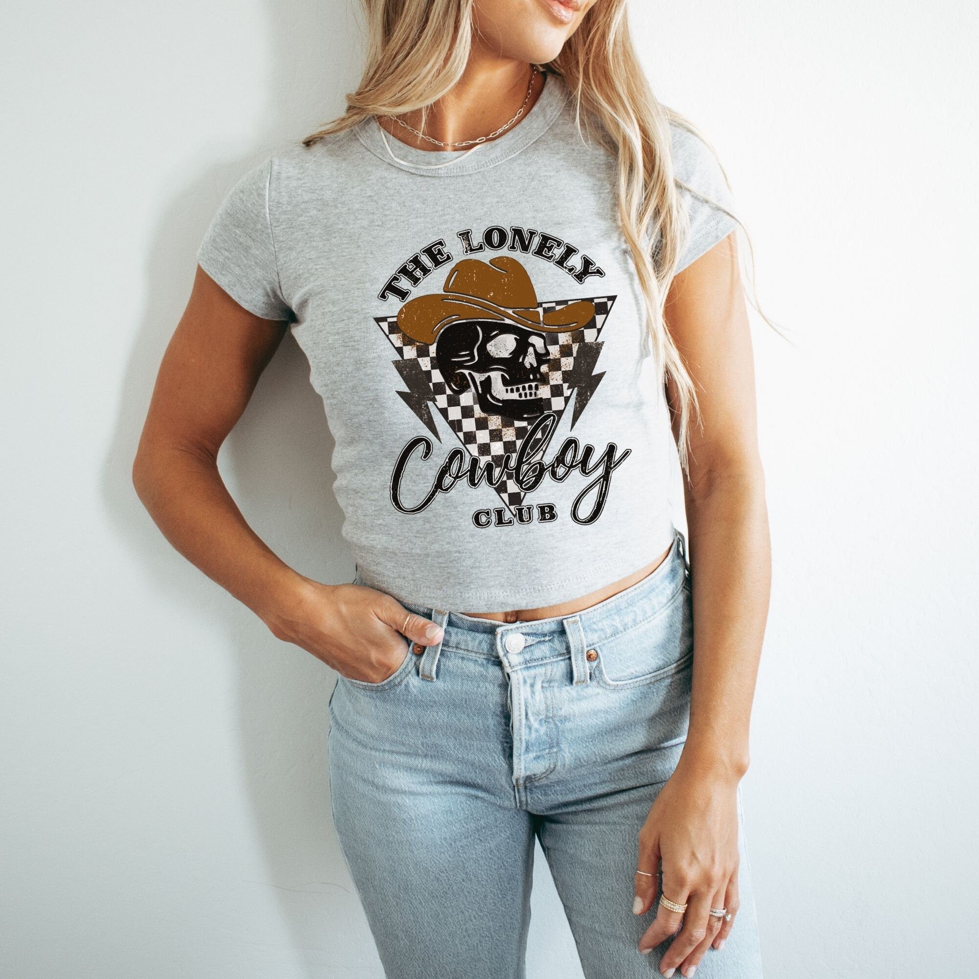 a woman wearing a grey shirt with a cowboy hat on it