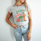 a woman wearing a t - shirt that says eat your veggies