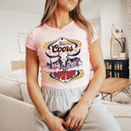 a woman sitting on a couch wearing a pink shirt
