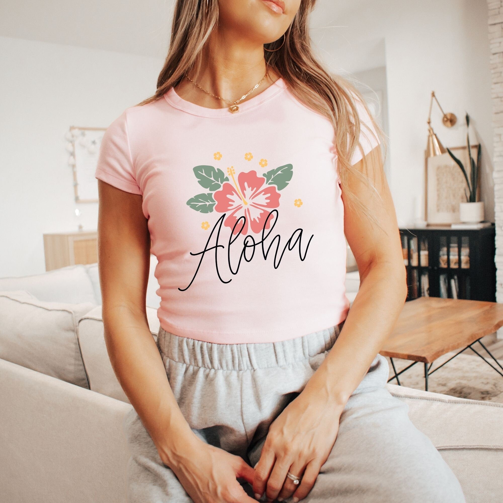 a woman sitting on a couch wearing a pink shirt