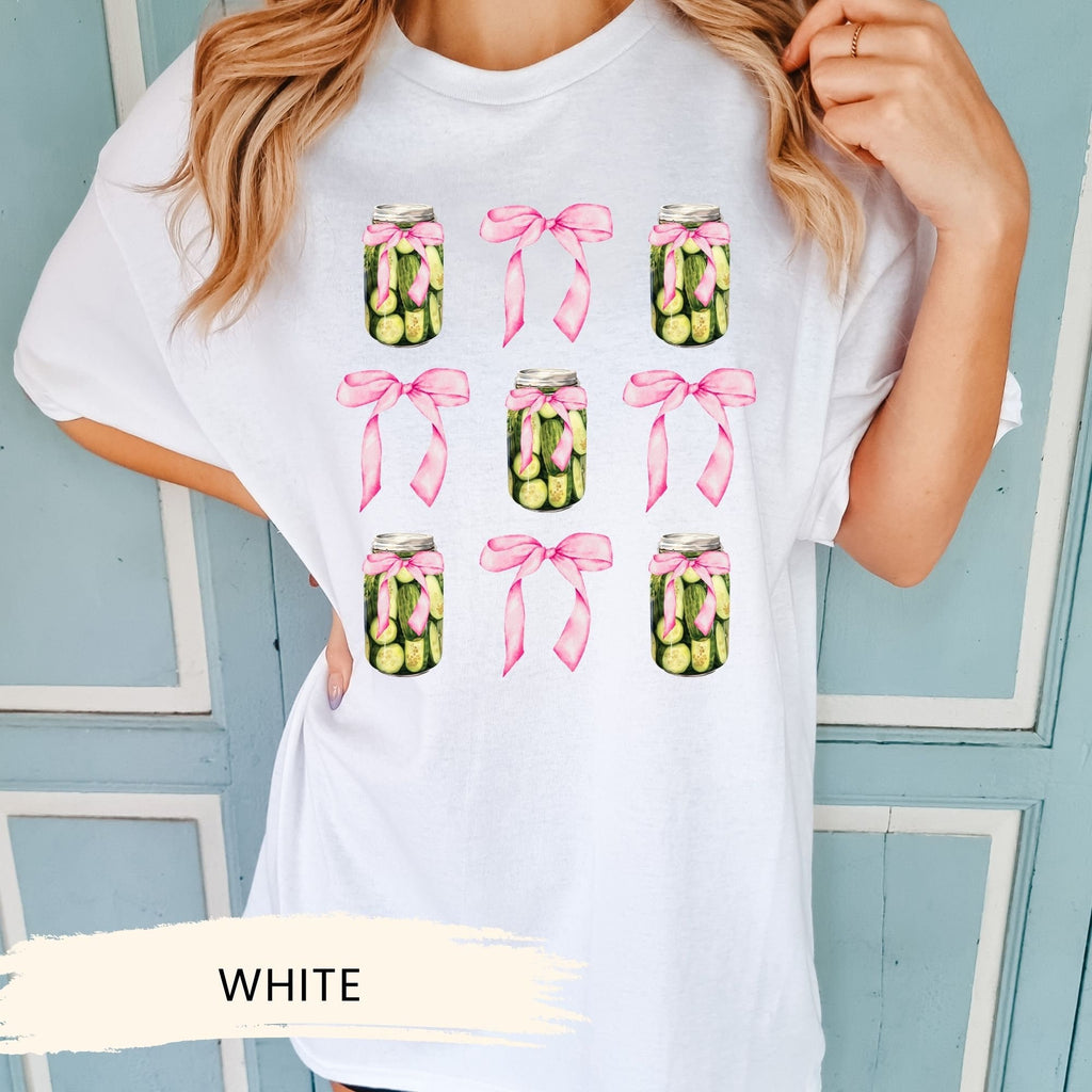 a woman wearing a white t - shirt with a jar of pickles on it