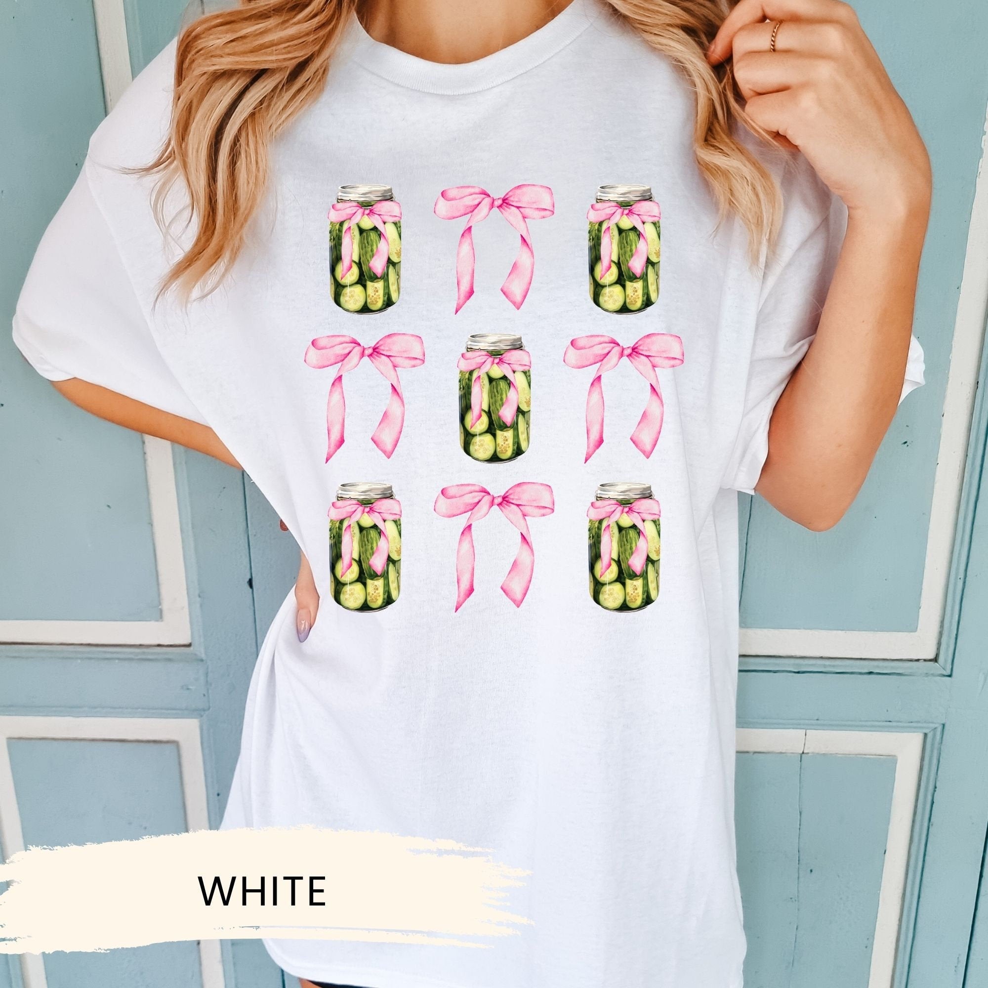 a woman wearing a white t - shirt with a jar of pickles on it