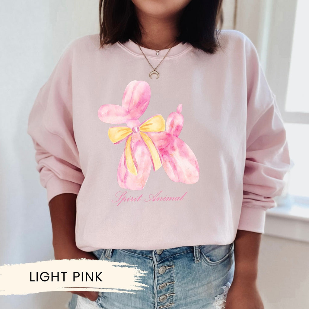 a woman wearing a pink sweatshirt with a yellow bow