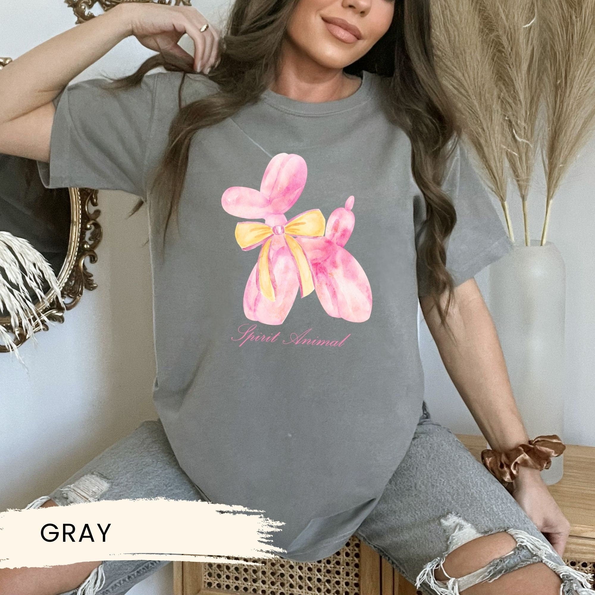 a woman wearing a gray shirt with a flower on it