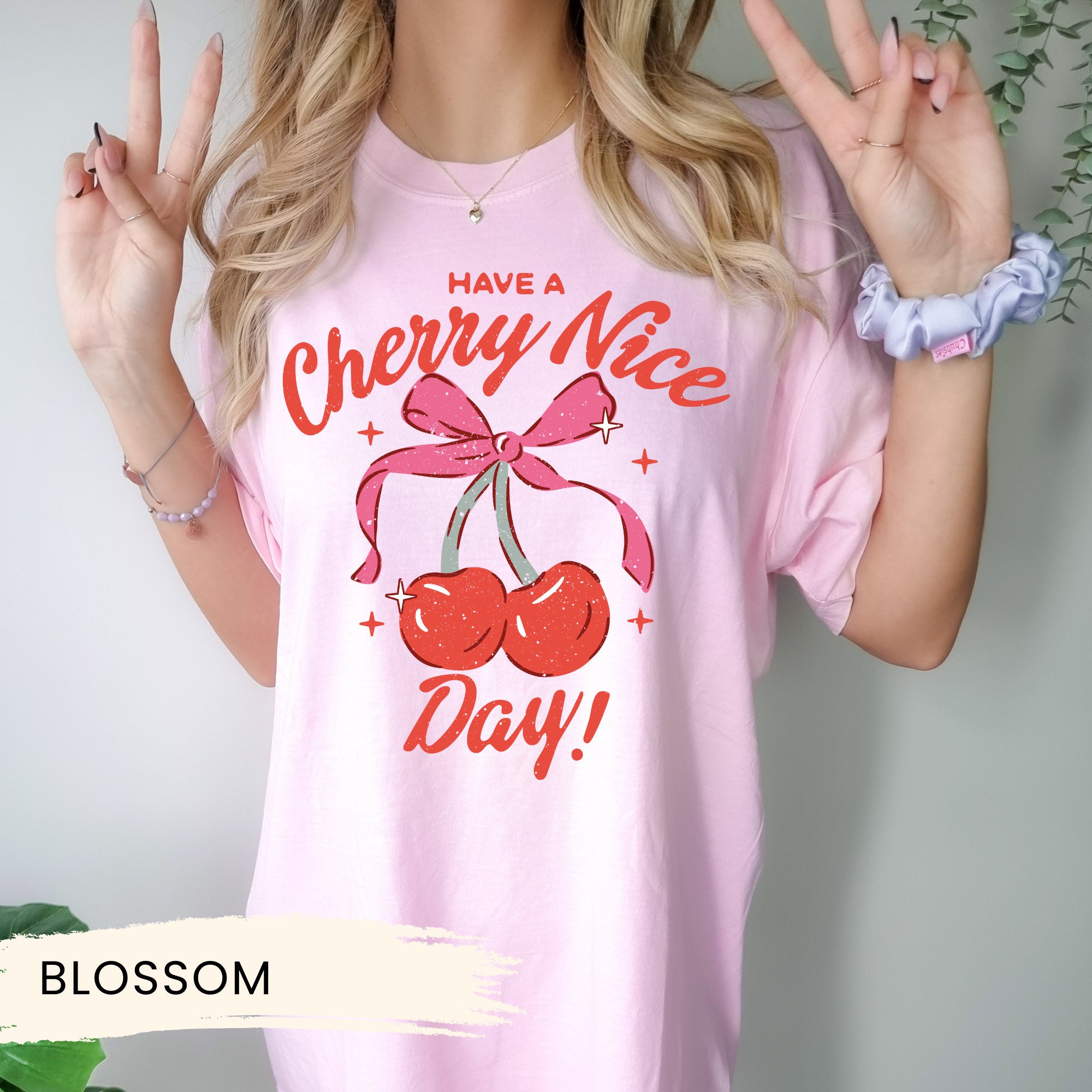 a woman wearing a pink cherry nice day shirt