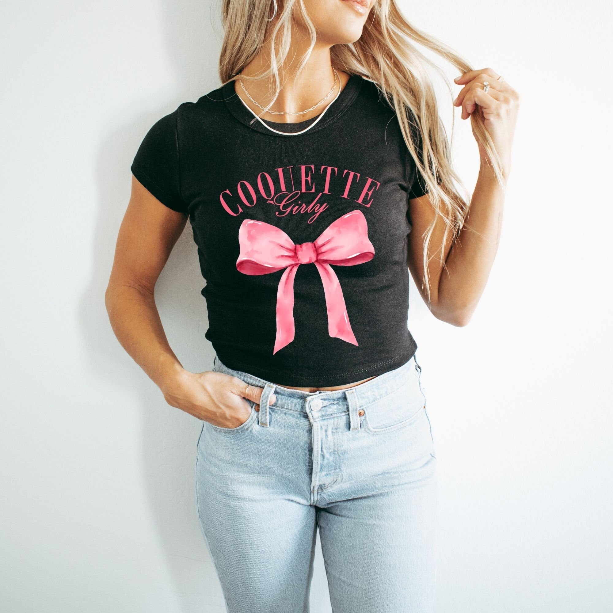 a woman wearing a black shirt with a pink bow