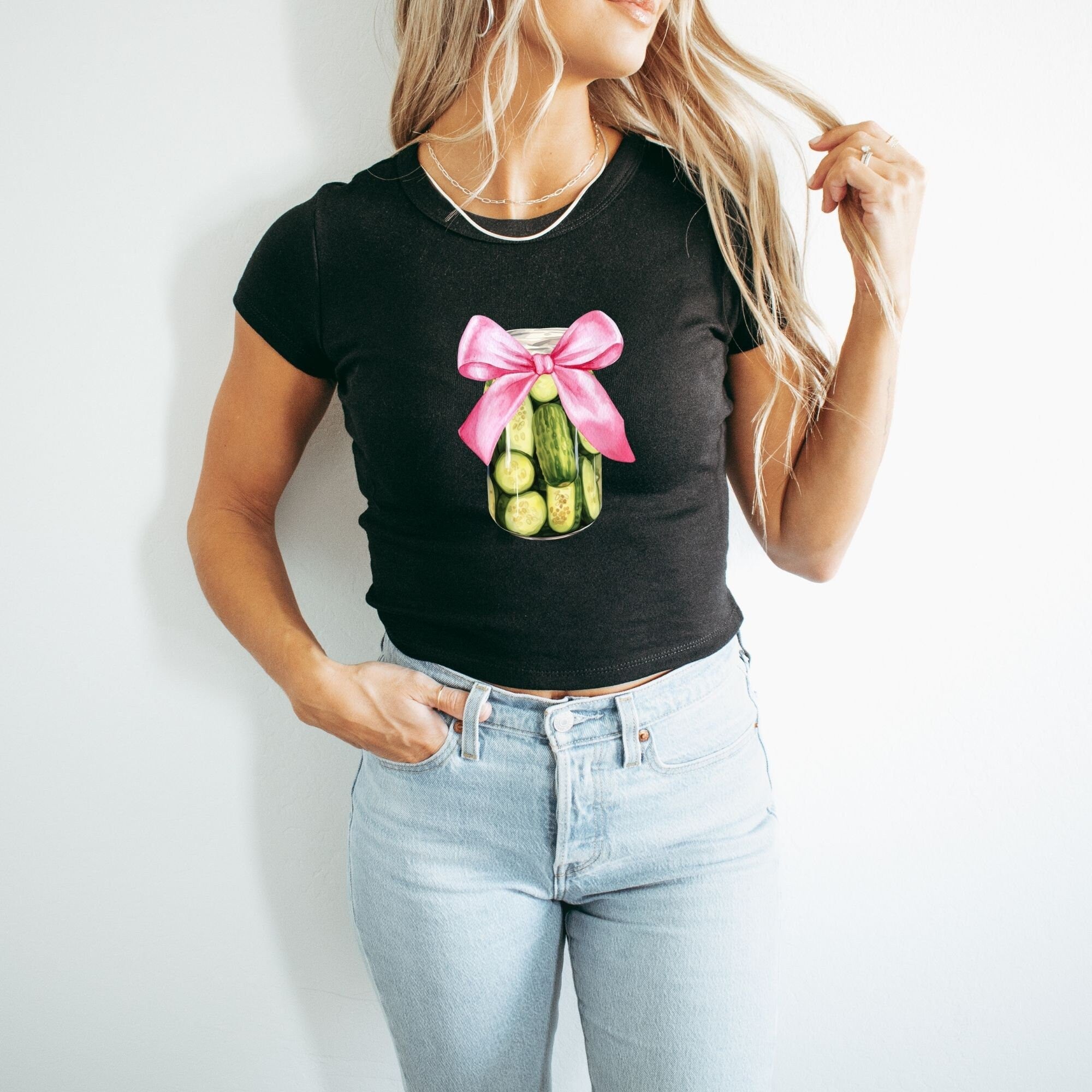a woman wearing a black shirt with a pink bow around her neck