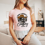 a woman sitting on a couch wearing a pink shirt