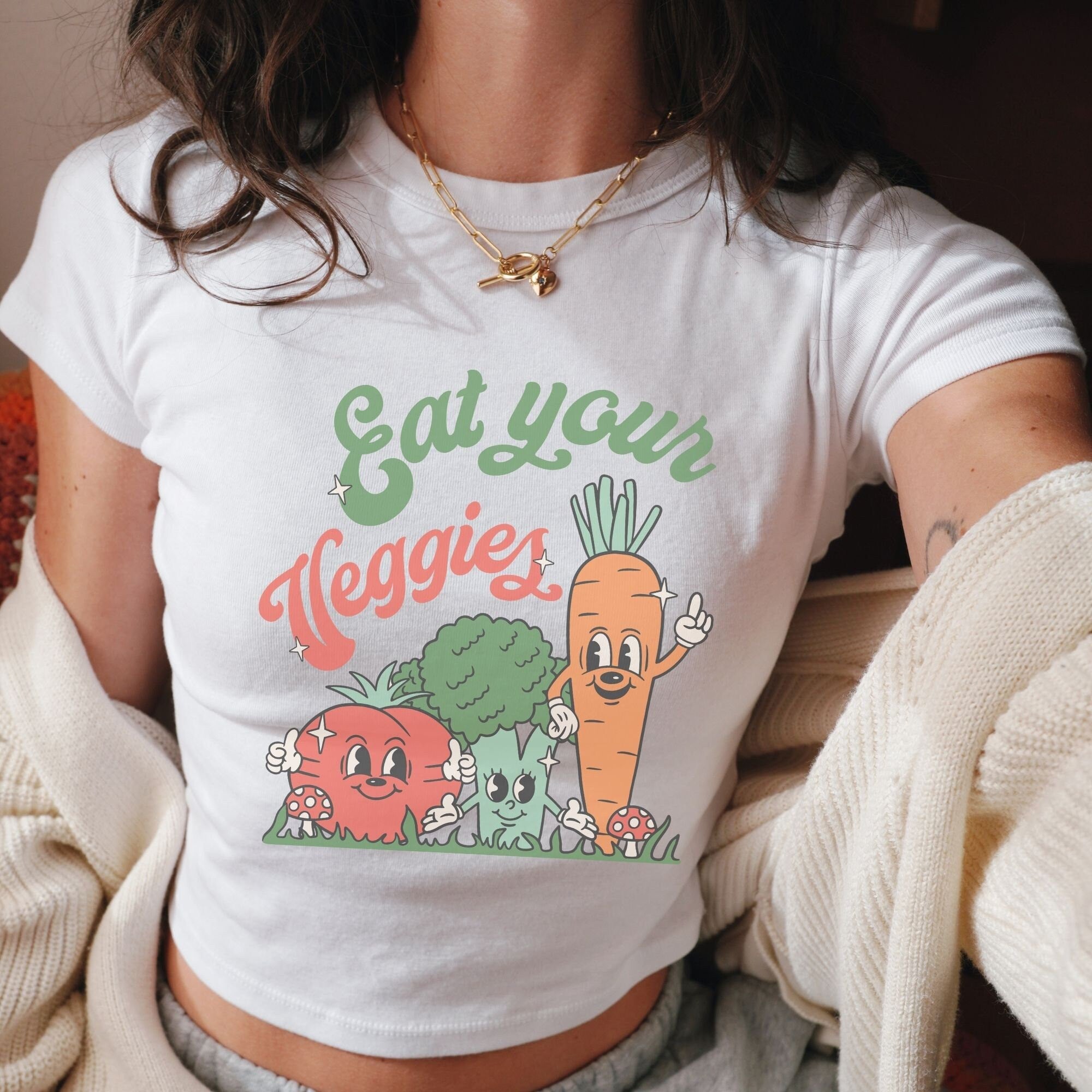 a woman wearing a t - shirt that says eat your veggies