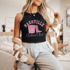 a woman wearing a black tank top with a pink boot on it