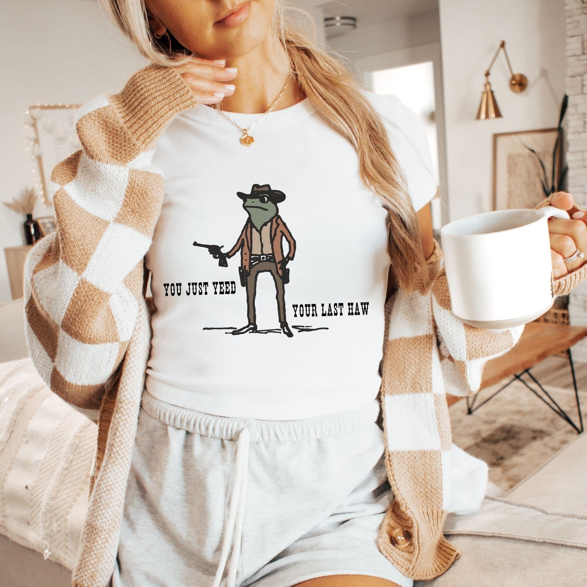 a woman holding a cup of coffee and a sweater