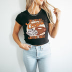 a woman wearing a black shirt with a coffee cup on it