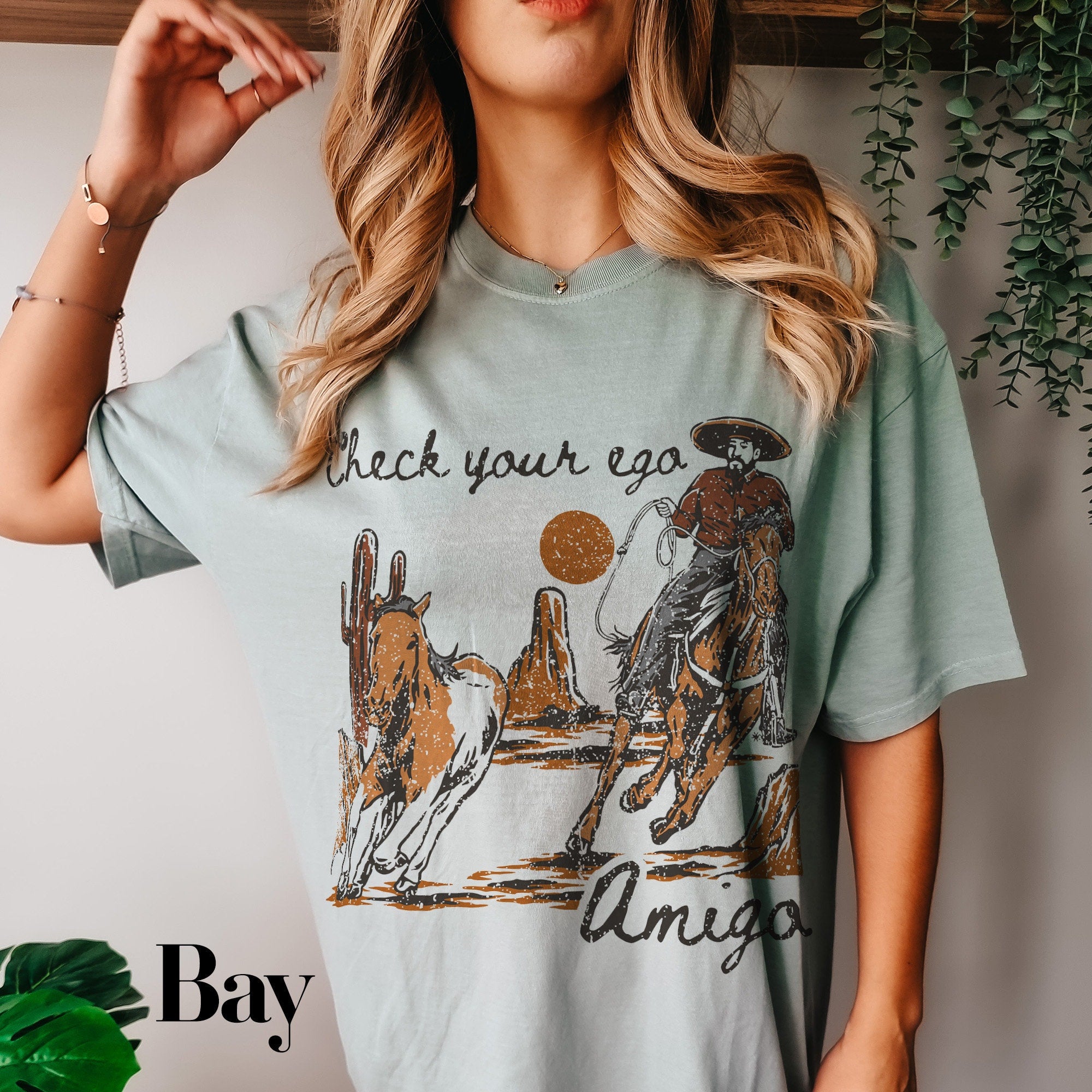 a woman wearing a t - shirt with an image of a cowboy riding a horse