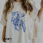 a woman wearing a white shirt with a blue graphic on it