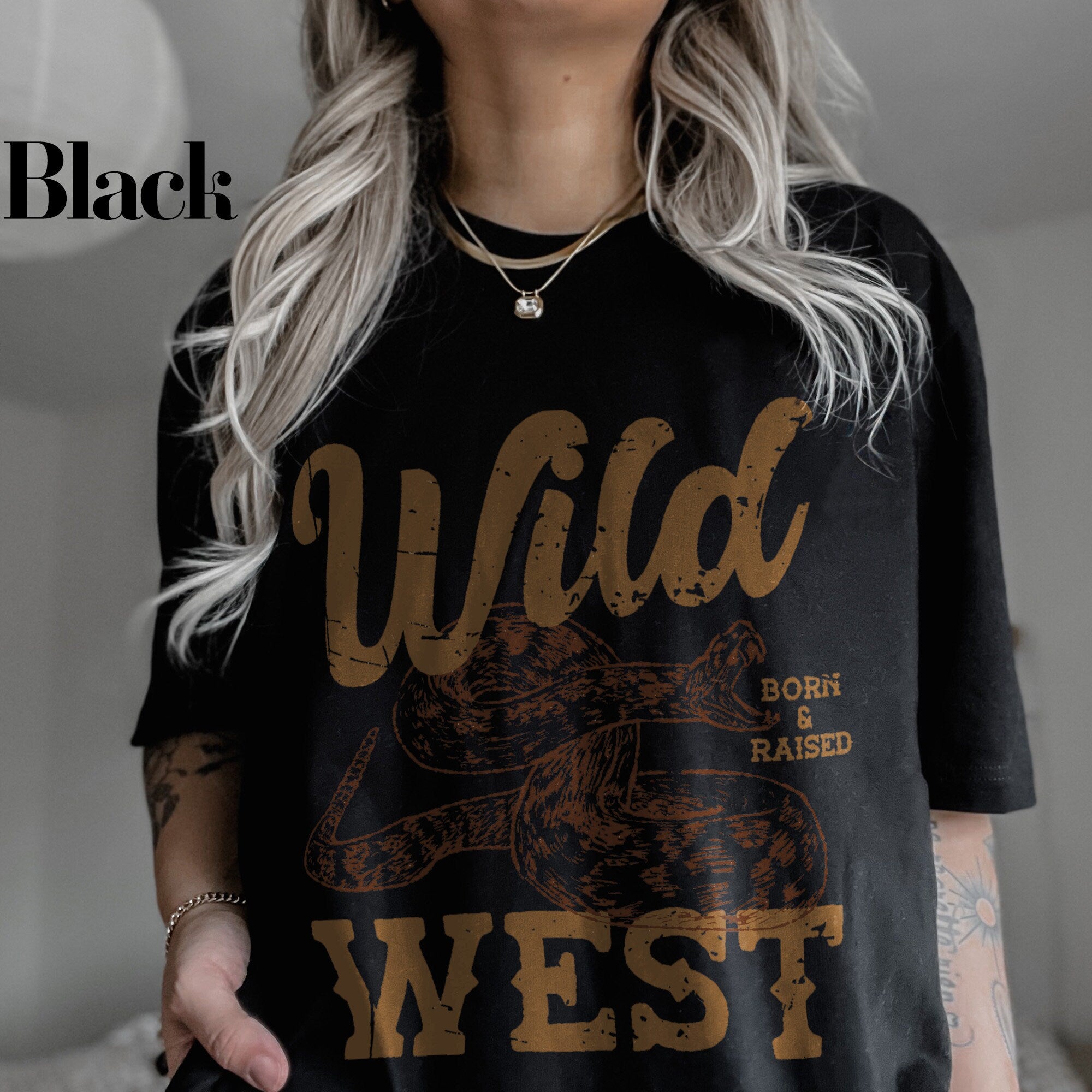 a woman wearing a black wild west t - shirt