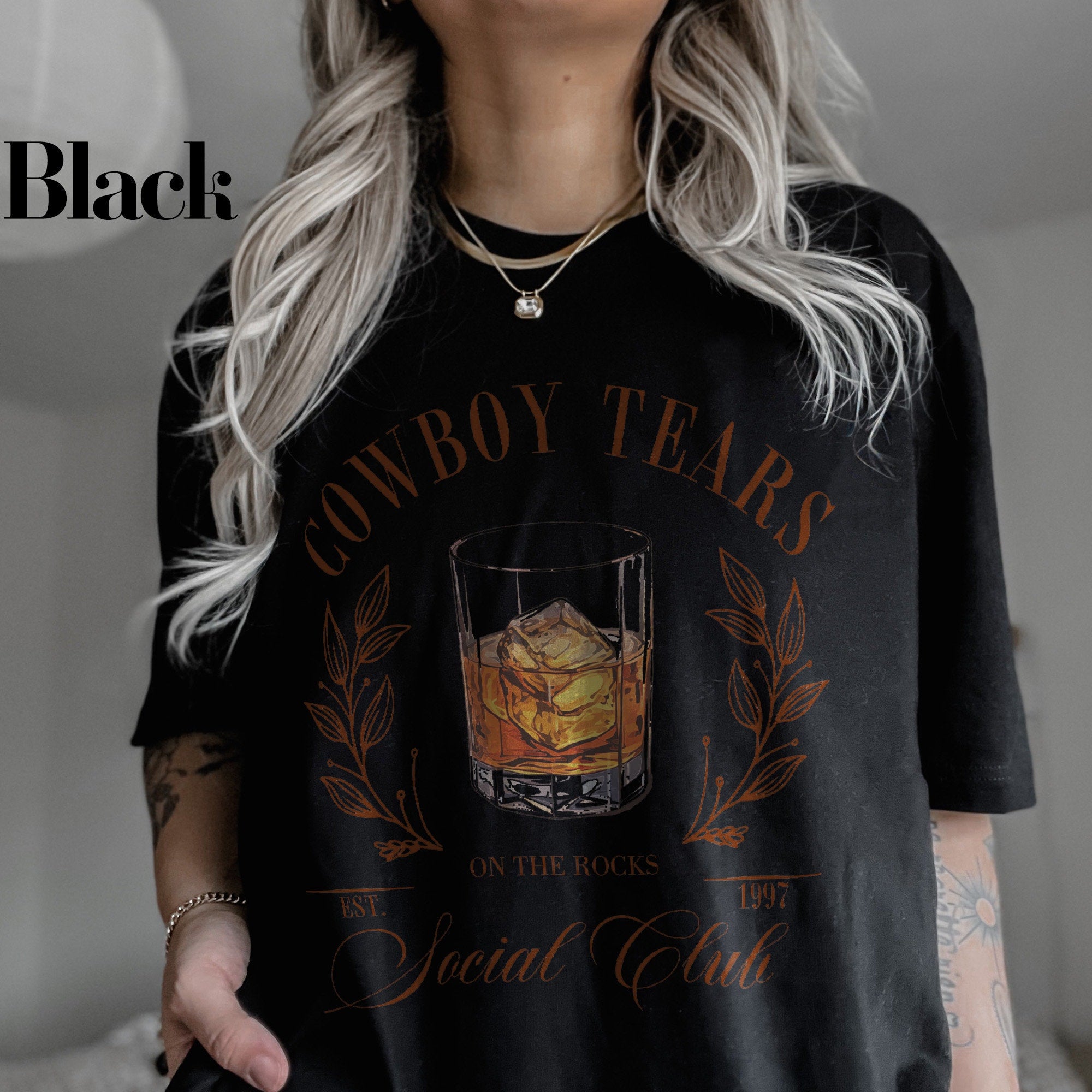 a woman wearing a cowboy tears t - shirt