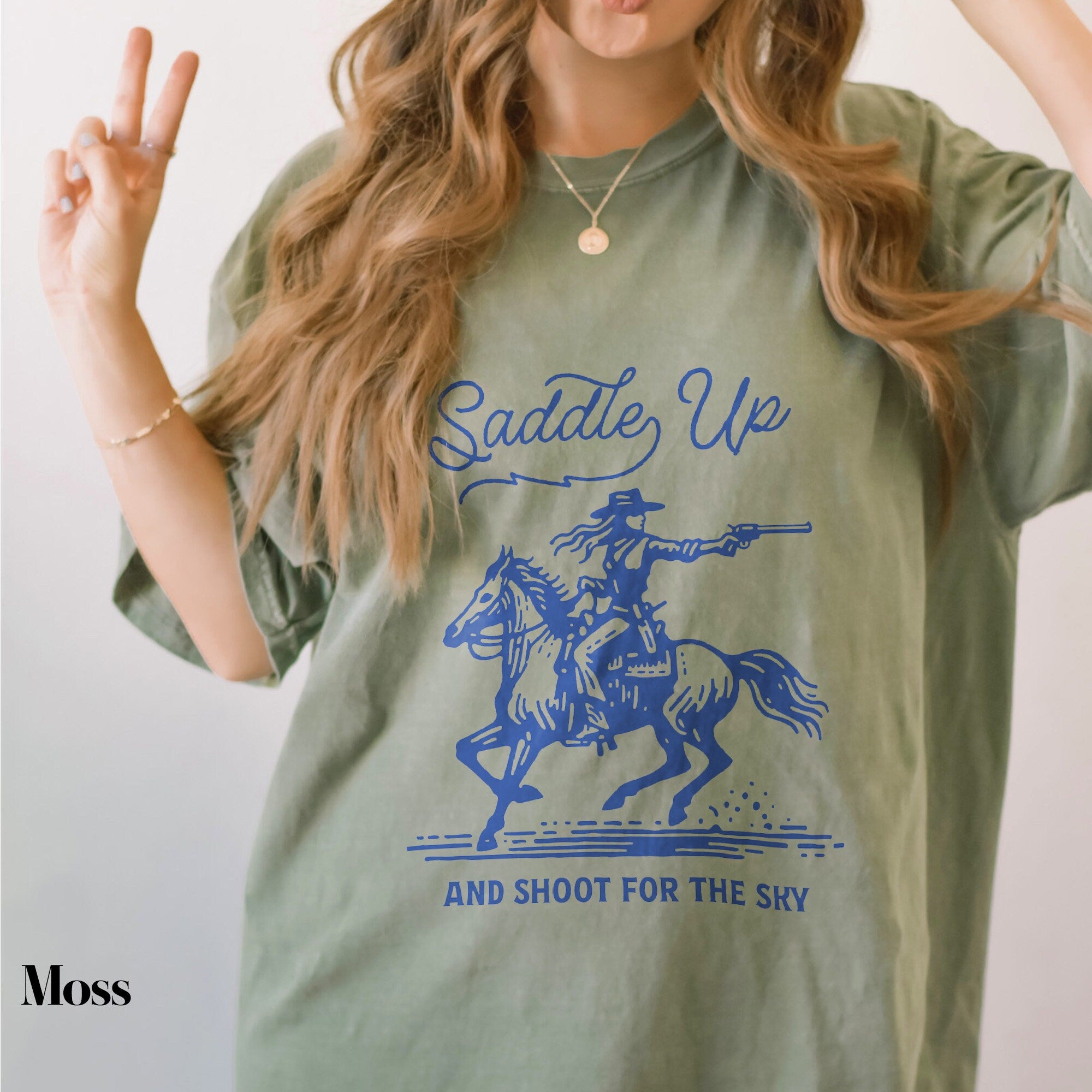a woman with long hair wearing a shirt that says salute up and shoot for the
