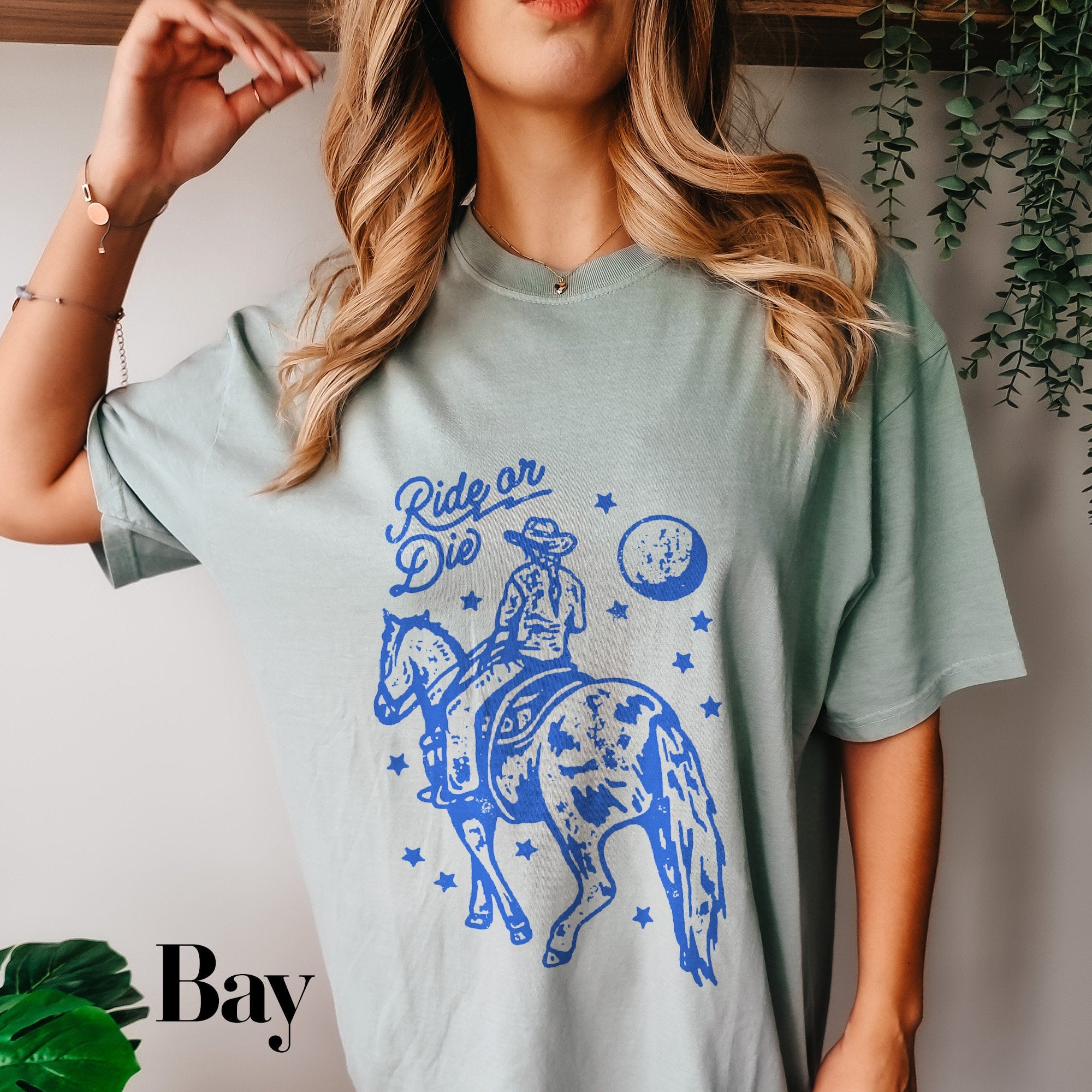 a woman wearing a t - shirt that says ride on the back of a horse